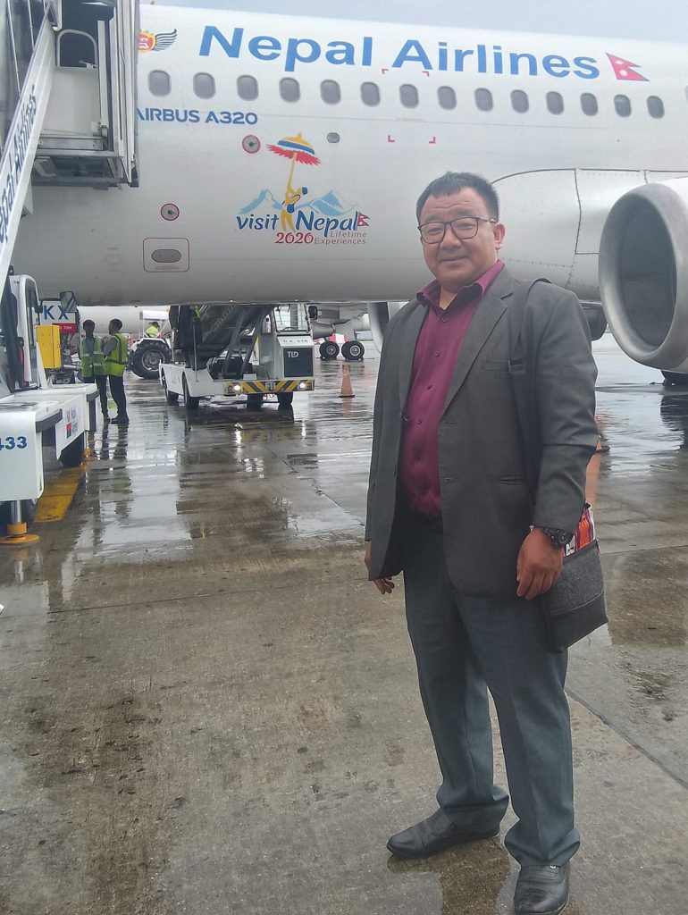 Deep B. Rai, Managing Director of Route Himalaya, standing in front of a Nepal Airlines Airbus A320 at Tribhuvan International Airport.